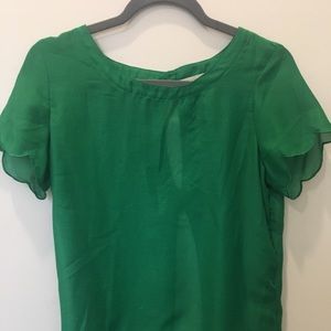 A green top with scalloped sleeves